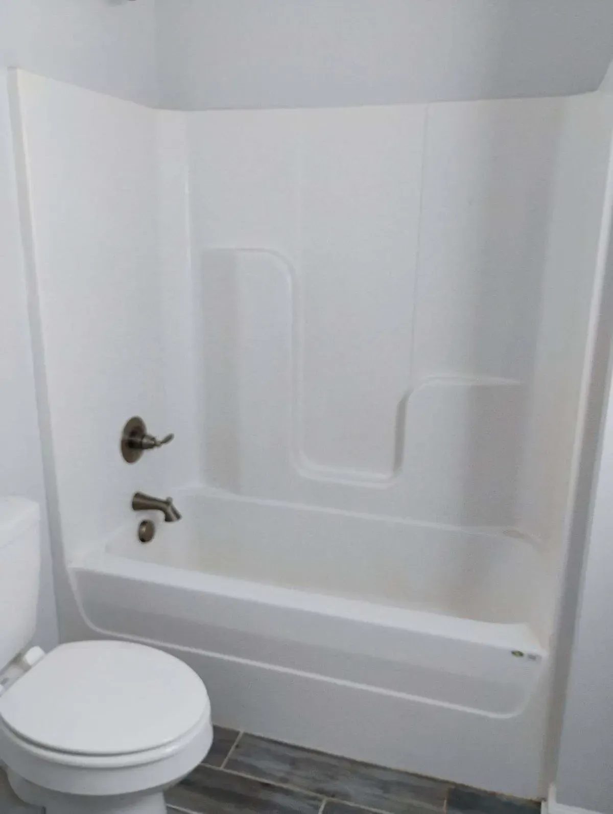 A white combination shower bathtub.